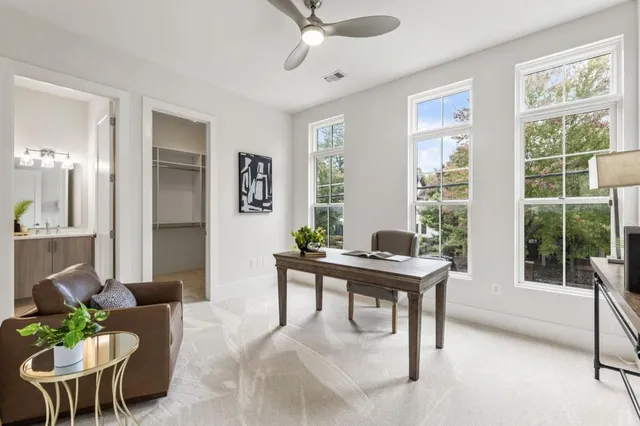 a view of a workspace with furniture and a window