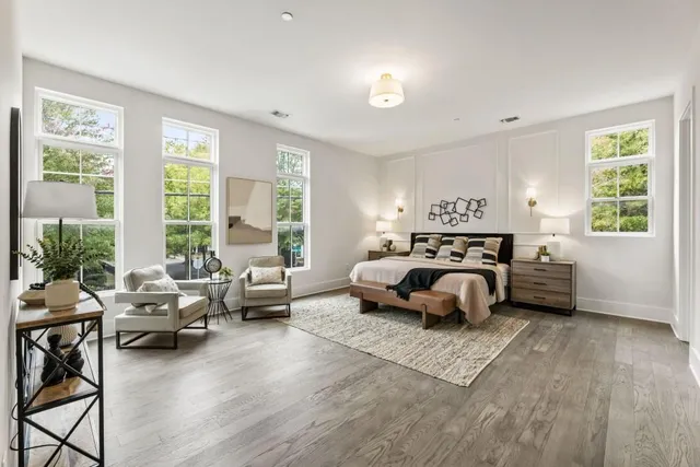 a spacious bedroom with a bed a couch and a large window