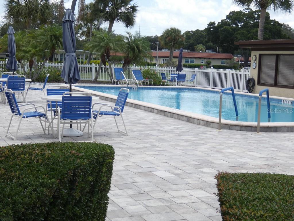 1701 Pinehurst Road, Unit 9G Dunedin, FL 34698 - Photo 13 of 22 a view of a patio with table and chairs potted plants and palm tree