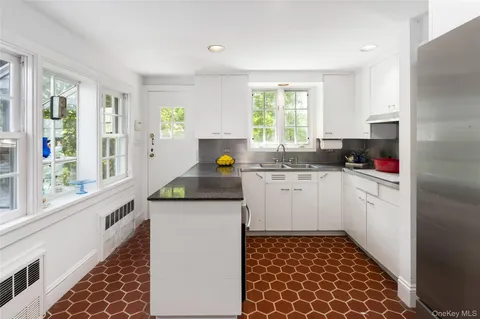 a kitchen with a sink window and cabinets
