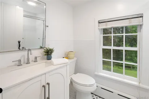 a bathroom with a sink a toilet and a window