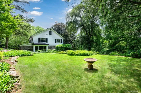 a view of a house with a yard and a fountain