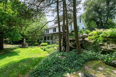 a view of yard with small fountain plants and large trees