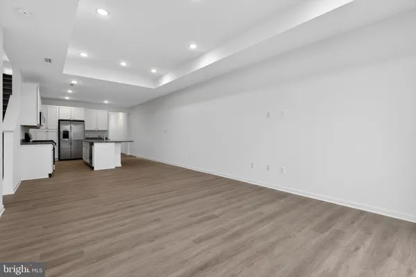 a view of kitchen with white cabinets and wooden floor