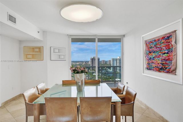 a view of a dining room with furniture a chandelier and wooden floor