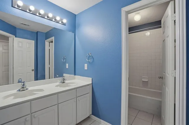 a bathroom with a double vanity sink and a mirror