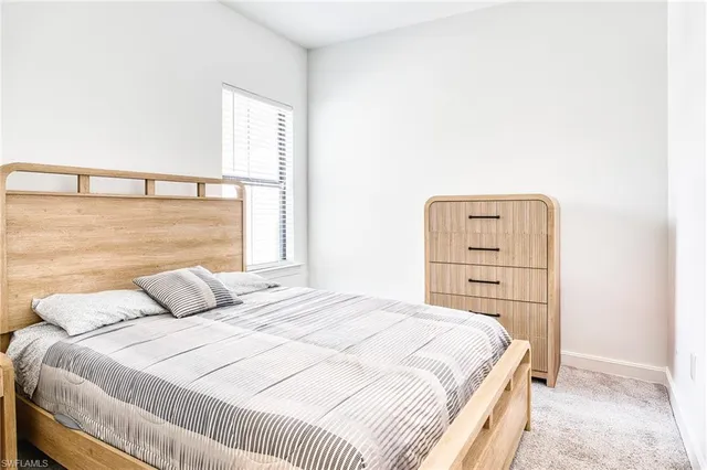 a bedroom with a bed a flat screen tv and a chandelier