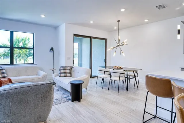 a living room with furniture a table and a large window
