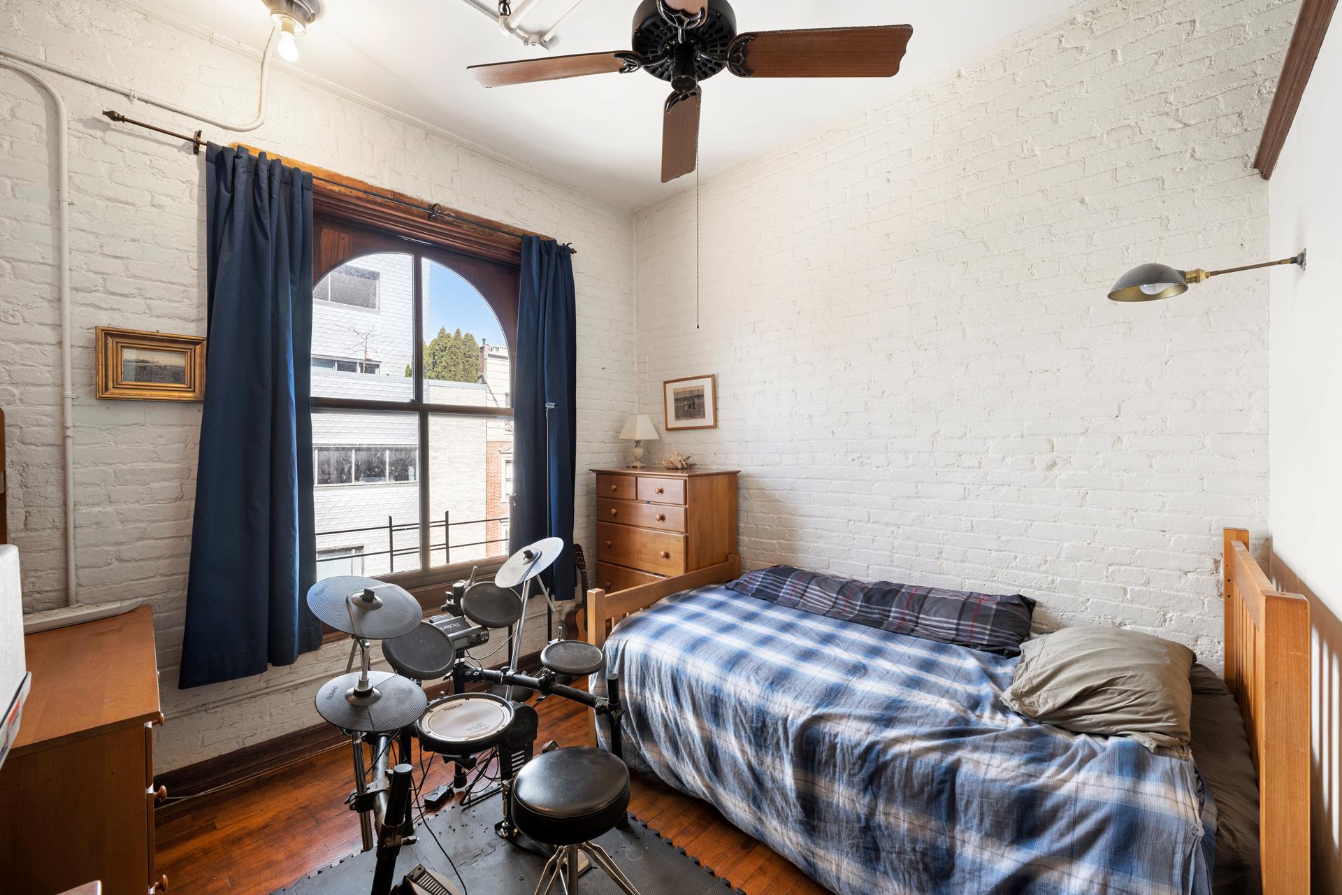 210 Spring Street, Unit 5 Manhattan, NY 10012 - Photo 5 of 13 a bedroom with a bed and wooden floor
