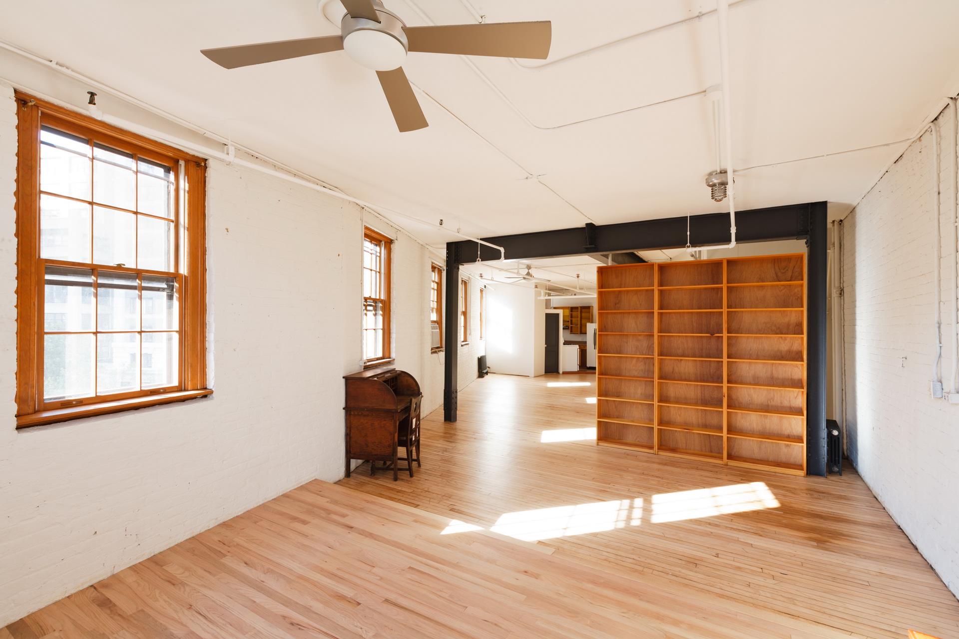 210 Spring Street, Unit 5 Manhattan, NY 10012 - Photo 7 of 13 a view of a room with wooden floor and windows