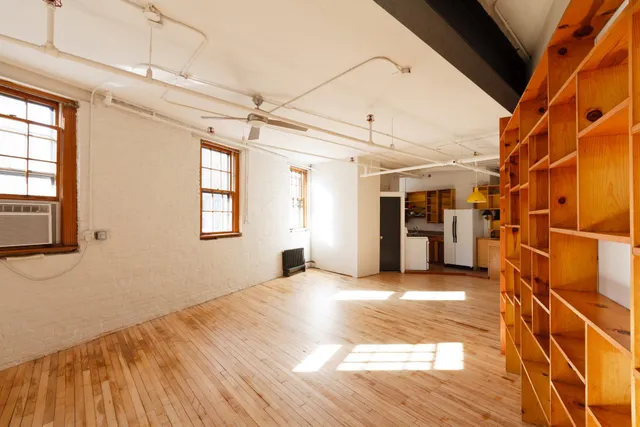 a view of a room with wooden floor and windows