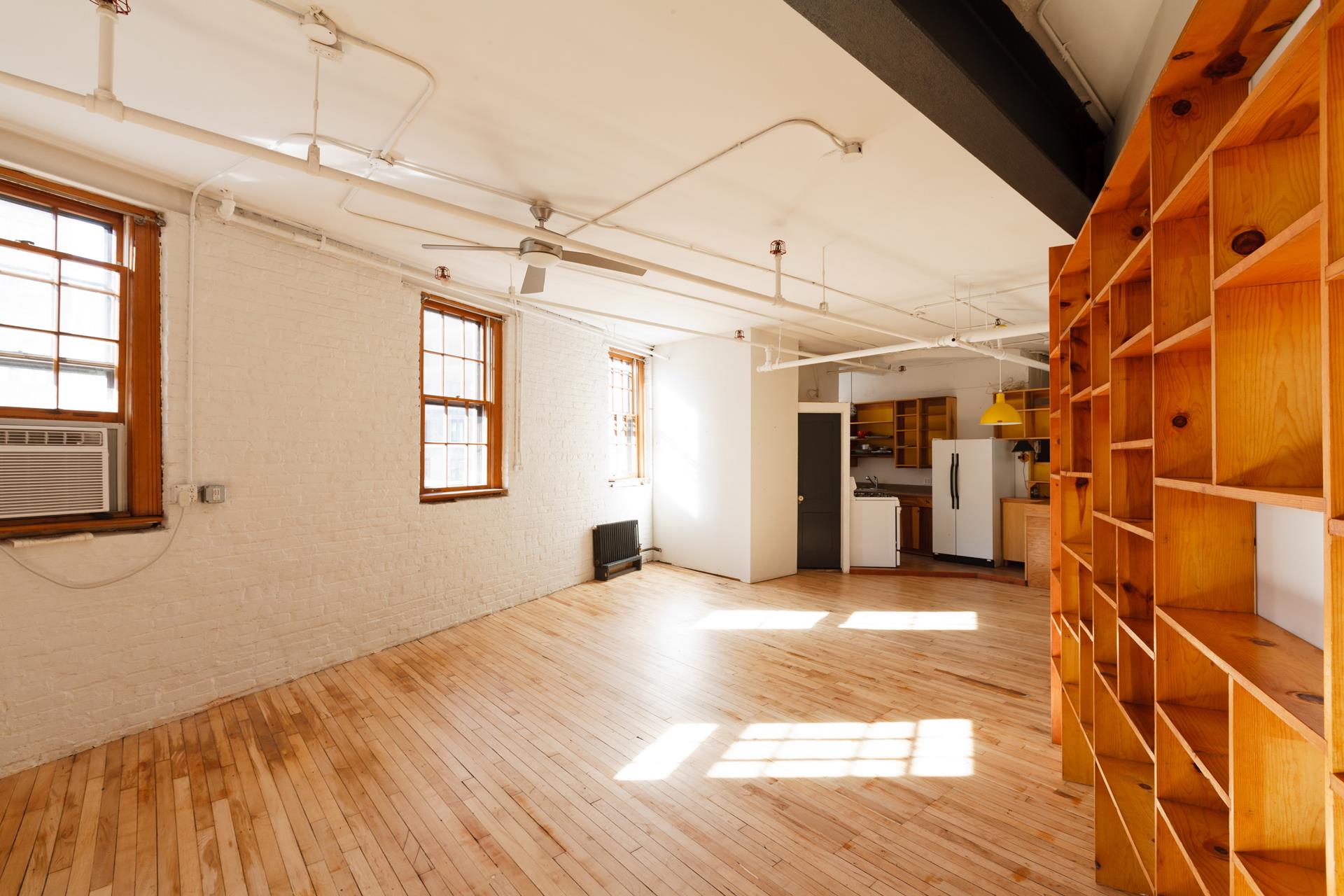 210 Spring Street, Unit 5 Manhattan, NY 10012 - Photo 8 of 13 a view of empty room with wooden floor and windows