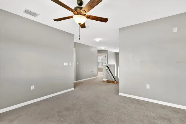 wooden floor in an empty room with a ceiling fan