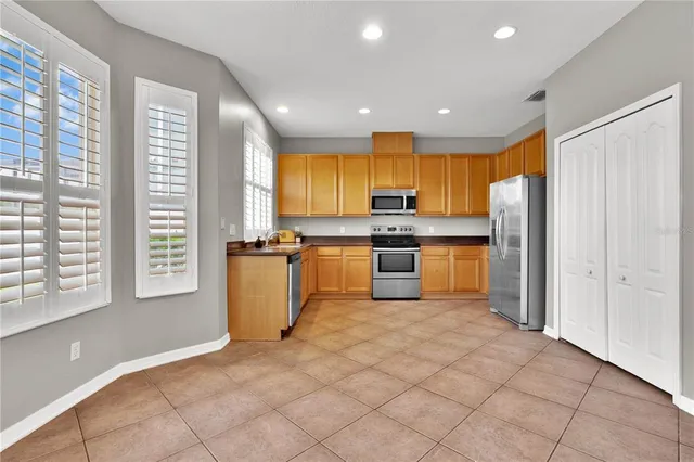 a kitchen with stainless steel appliances granite countertop a stove a sink and a refrigerator