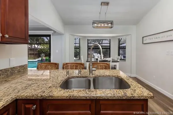 a kitchen with a sink a counter top space and living room
