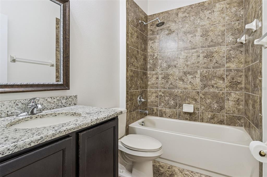 31518 Bearded Oak Drive Wesley Chapel, FL 33543 - Photo 33 of 56 a bathroom with a granite countertop bathtub sink vanity mirror and toilet