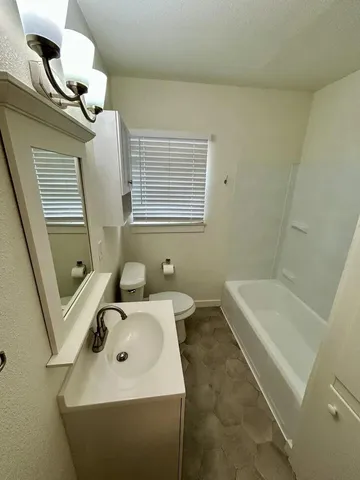a bathroom with a sink a toilet and bathtub
