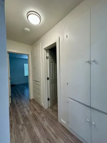 a view of a hallway with wooden floor