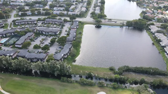 an aerial view of residential houses with outdoor space and lake view