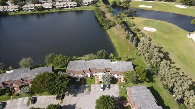 an aerial view of a house with a yard and lake view