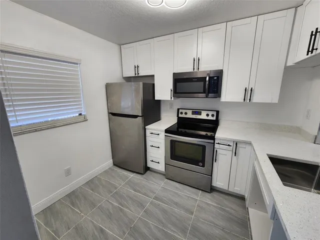 a kitchen with a refrigerator stove and microwave