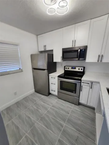 a kitchen with a refrigerator a stove top oven a sink and dishwasher