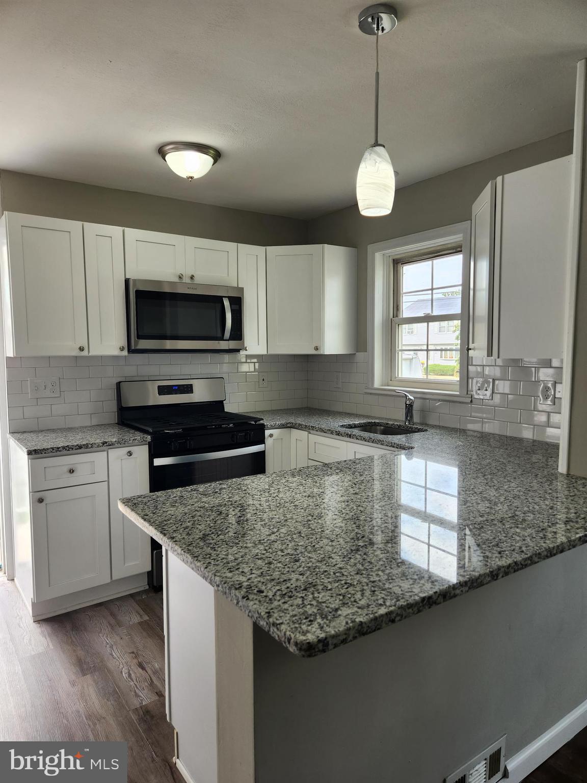 10 Webster Avenue Stratford, NJ 08084 - Photo 14 of 20 a kitchen with stainless steel appliances granite countertop a sink a stove a microwave and wooden cabinets