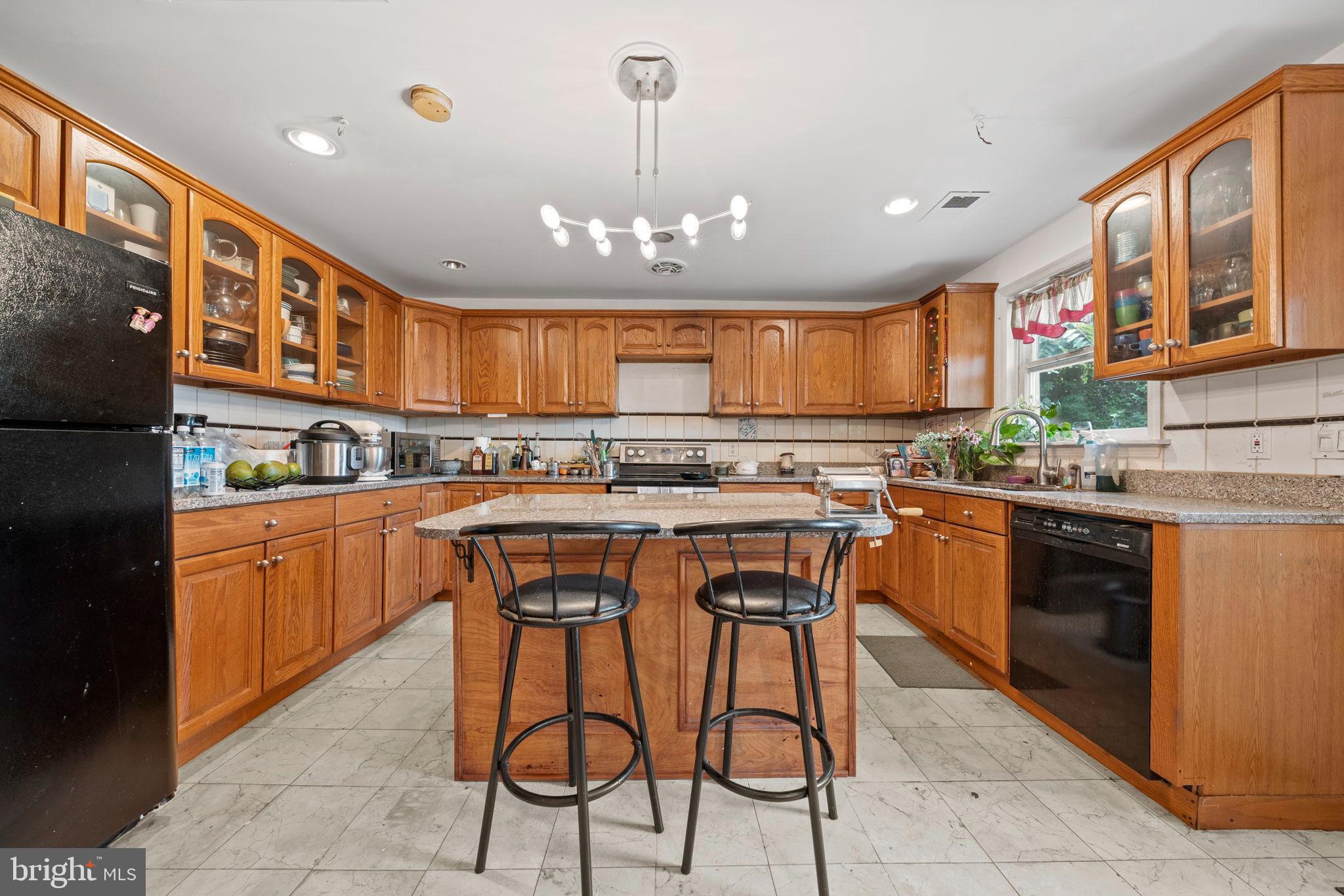 6517 29th Street North Arlington, VA 22213 - Photo 11 of 49 a kitchen with stainless steel appliances kitchen island granite countertop a table chairs sink and cabinets