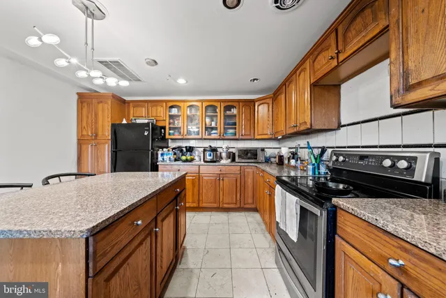 a kitchen with stainless steel appliances granite countertop a stove a sink and a refrigerator