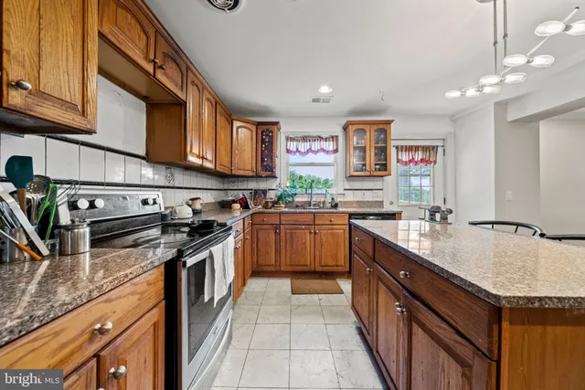 a kitchen with stainless steel appliances granite countertop a stove a sink dishwasher and a refrigerator