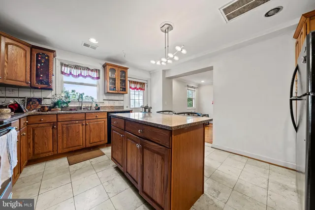 a kitchen with stainless steel appliances granite countertop a sink counter space cabinets and a large window