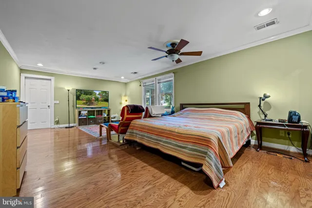 a spacious bedroom with a bed a table and a potted plant