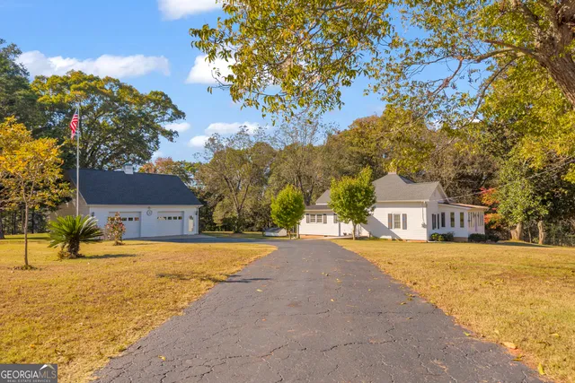 a front view of a building with a yard and trees