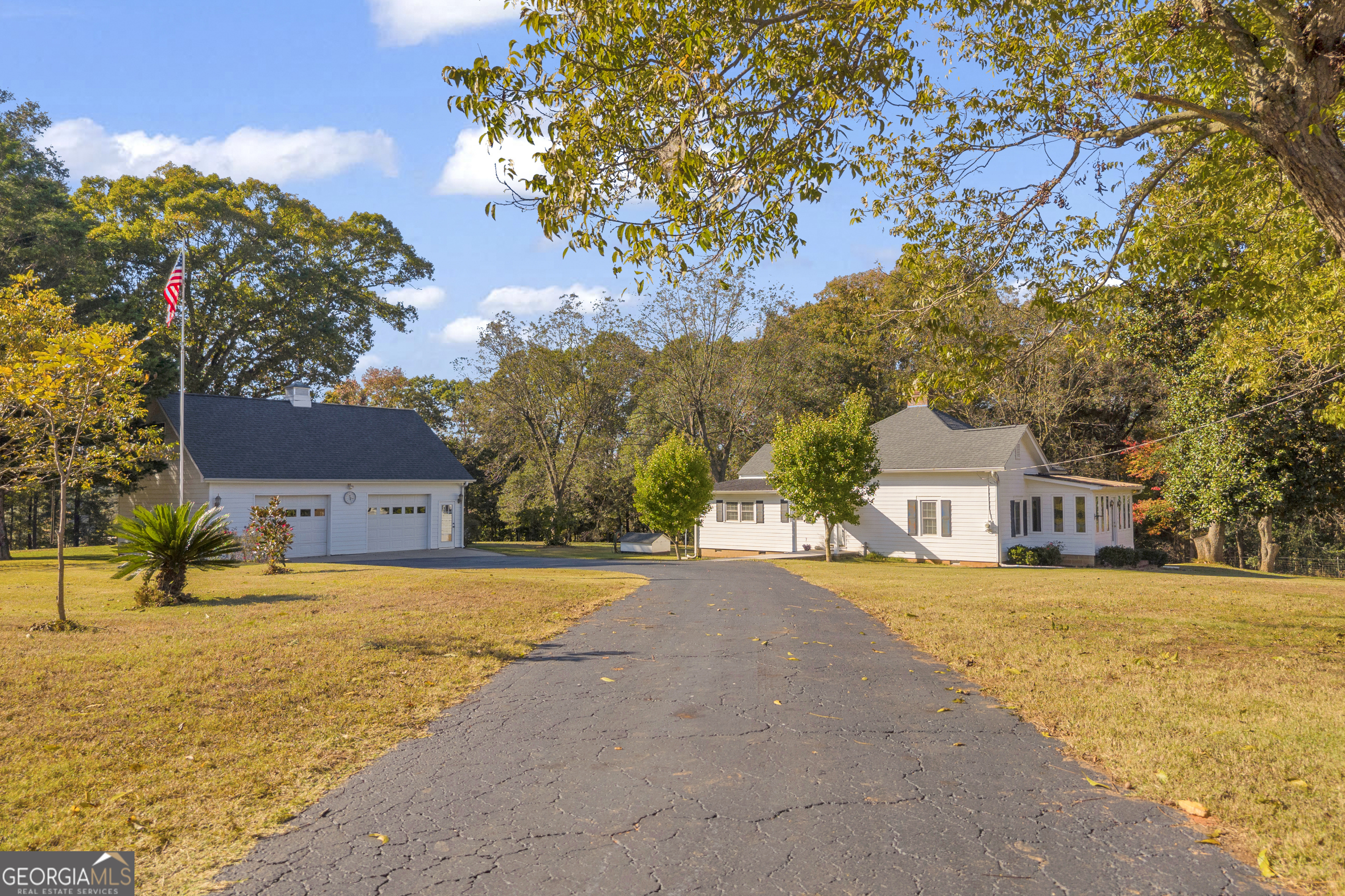 a front view of a building with a yard and trees