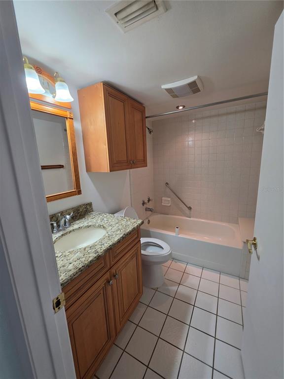 1281 Pine Ridge Circle East, Unit B1 Tarpon Springs, FL 34688 - Photo 15 of 30 a bathroom with a granite countertop sink toilet and shower