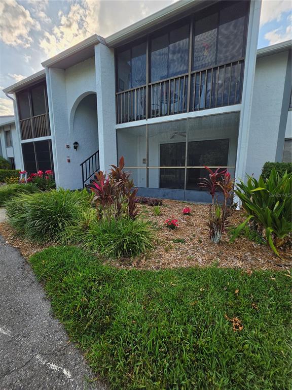 1281 Pine Ridge Circle East, Unit B1 Tarpon Springs, FL 34688 - Photo 3 of 30 a view of a house with a small yard and a large window