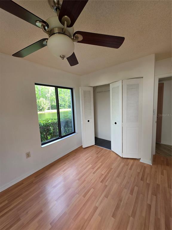 1281 Pine Ridge Circle East, Unit B1 Tarpon Springs, FL 34688 - Photo 8 of 30 a view of an empty room with wooden floor and a window