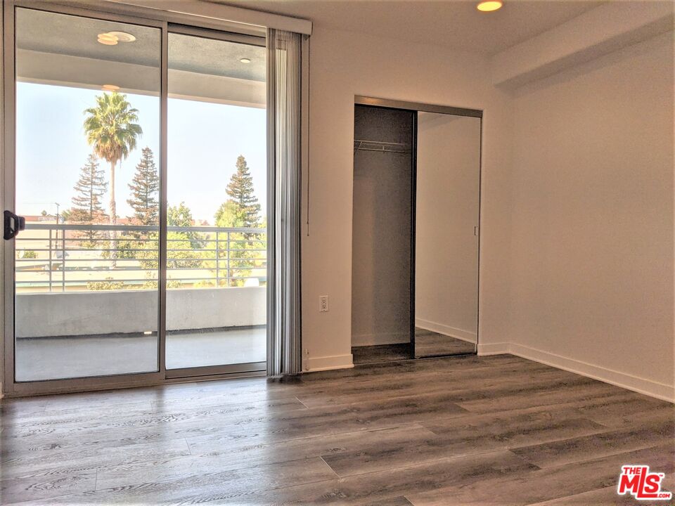 5143 White Oak Avenue, Unit 306 Encino, CA 91316 - Photo 11 of 32 a view of an empty room with wooden floor and a window