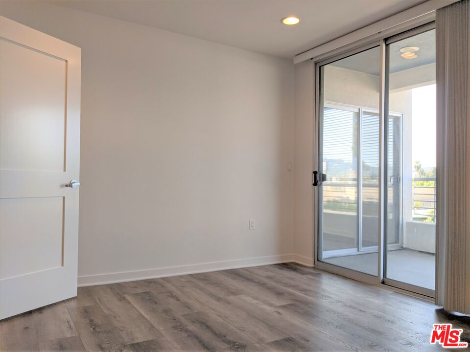 5143 White Oak Avenue, Unit 306 Encino, CA 91316 - Photo 12 of 32 an empty room with wooden floor and windows