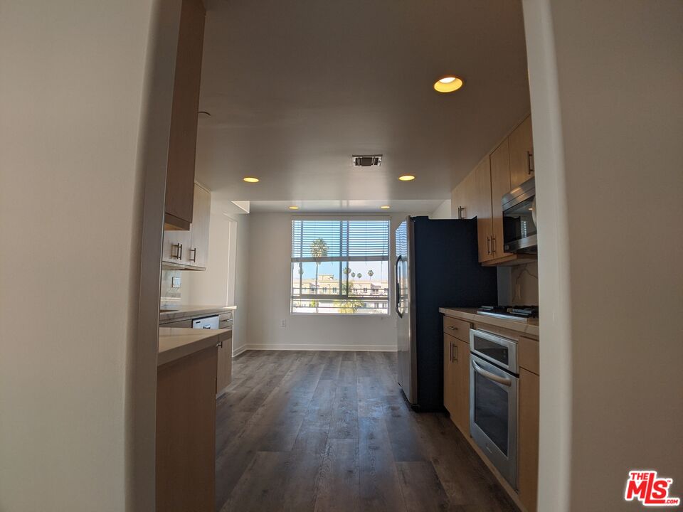 5143 White Oak Avenue, Unit 306 Encino, CA 91316 - Photo 20 of 32 a kitchen with stainless steel appliances granite countertop a refrigerator and a stove top oven
