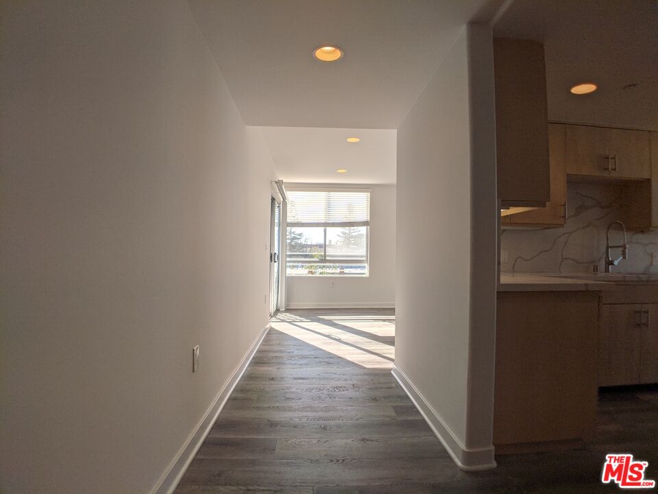 5143 White Oak Avenue, Unit 306 Encino, CA 91316 - Photo 21 of 32 a view of a hallway with wooden floor and a bathroom