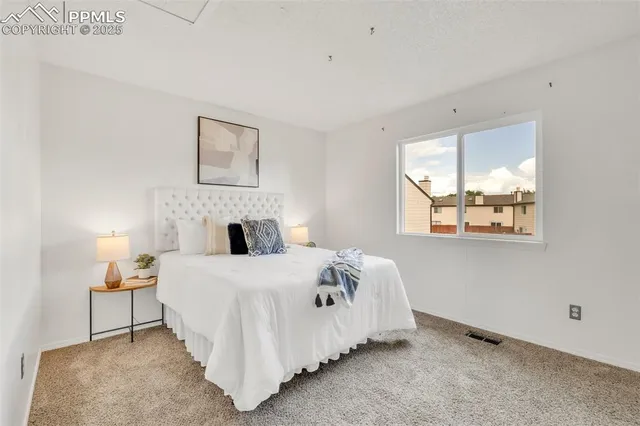 a bed sitting in a bedroom next to a window with a tv and a fireplace