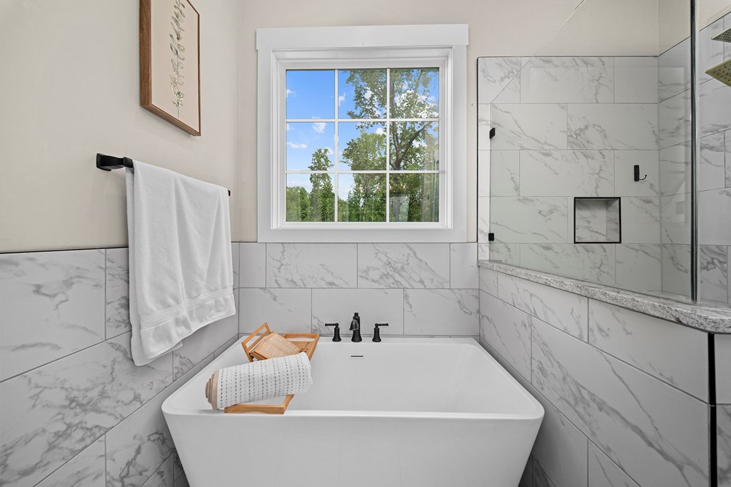 392 London Road Ball Ground, GA 30107 - Photo 7 of 60 a white bath tub sitting in a bathroom next to a window