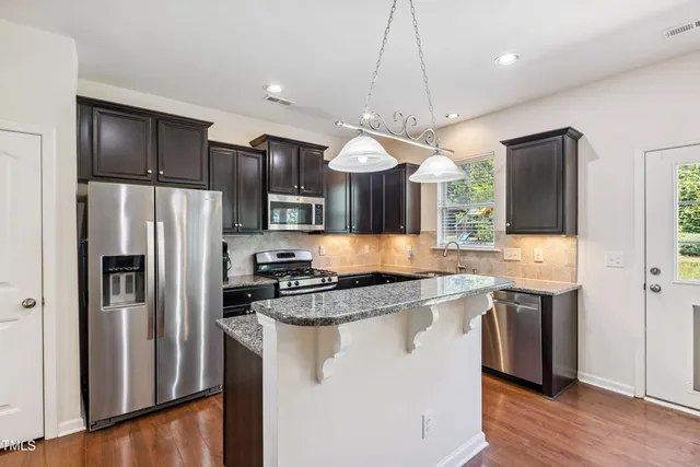 a kitchen with stainless steel appliances granite countertop a refrigerator a stove a sink and a refrigerator