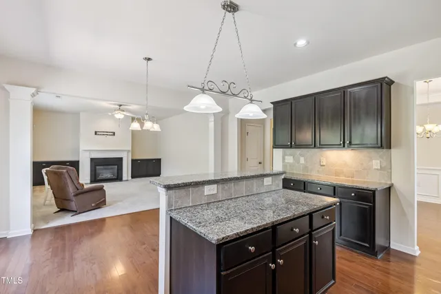 a kitchen with stainless steel appliances granite countertop a sink a stove and a wooden floors