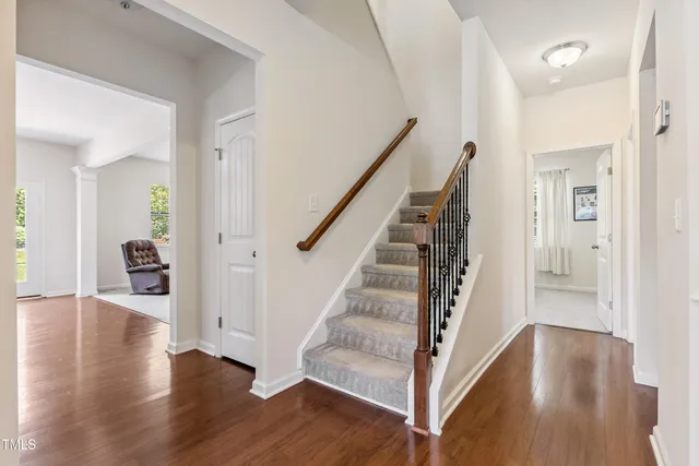 a view of a hallway with wooden floor and stairs