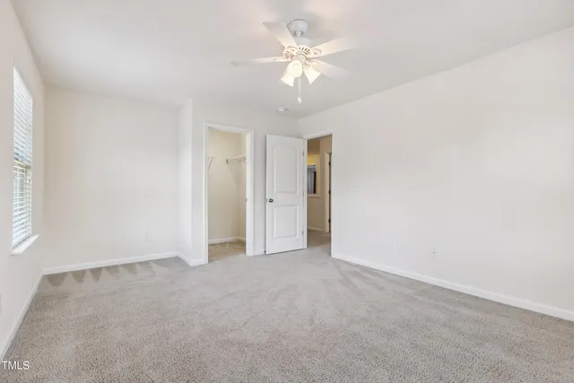 a view of an empty room with a ceiling fan