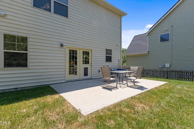 a view of a patio with a table and chairs and potted plants