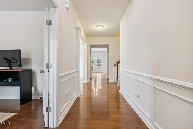 a view of a hallway with wooden floor and closet