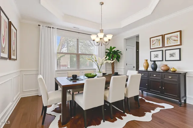 a dining room with furniture a chandelier and wooden floor
